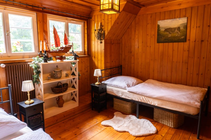 Schlafzimmer mit Kommode und Spiegel am Fenster
