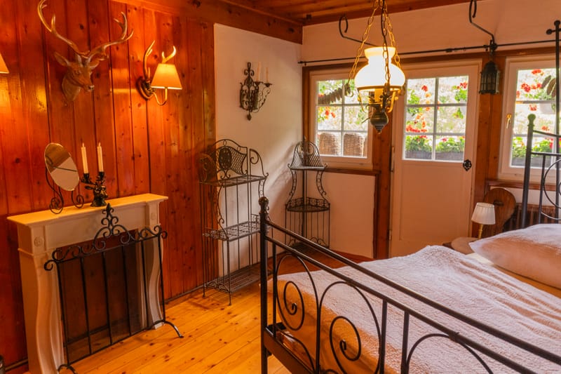 Schlafzimmer mit schmiedeeisernem Bett und Kommode