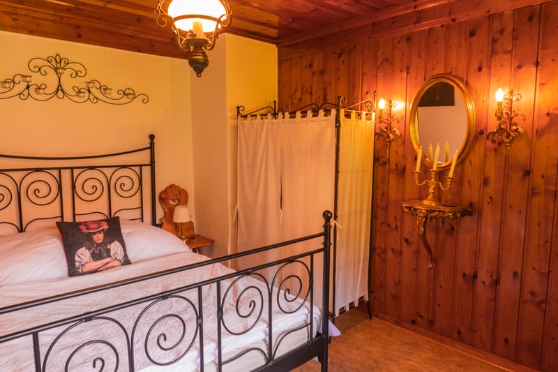 Schlafzimmer mit Holzwand und stimmungsvollem Licht